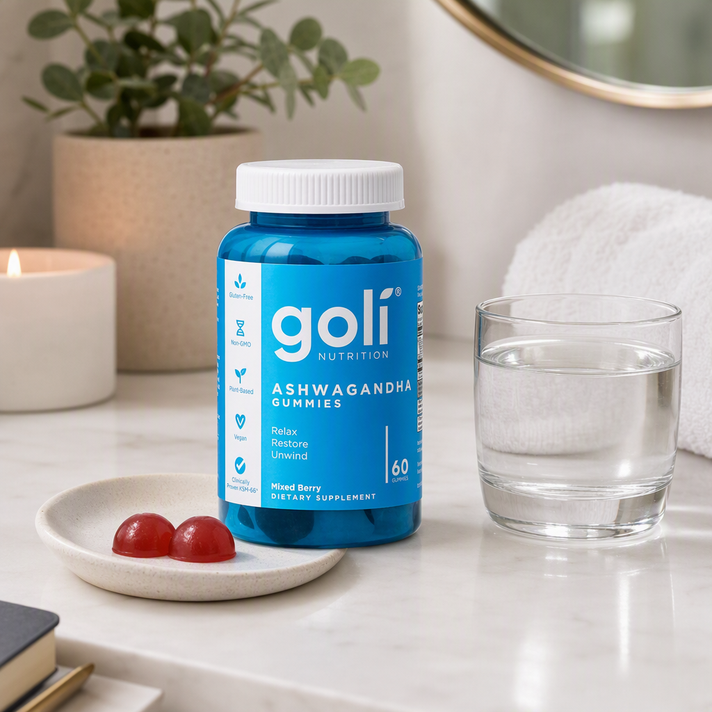 AI-generated Goli ad: a blue Ashwagandha Gummies bottle on a marble bathroom counter beside two red gummies on a ceramic dish, a glass of water, a lit candle and a eucalyptus plant