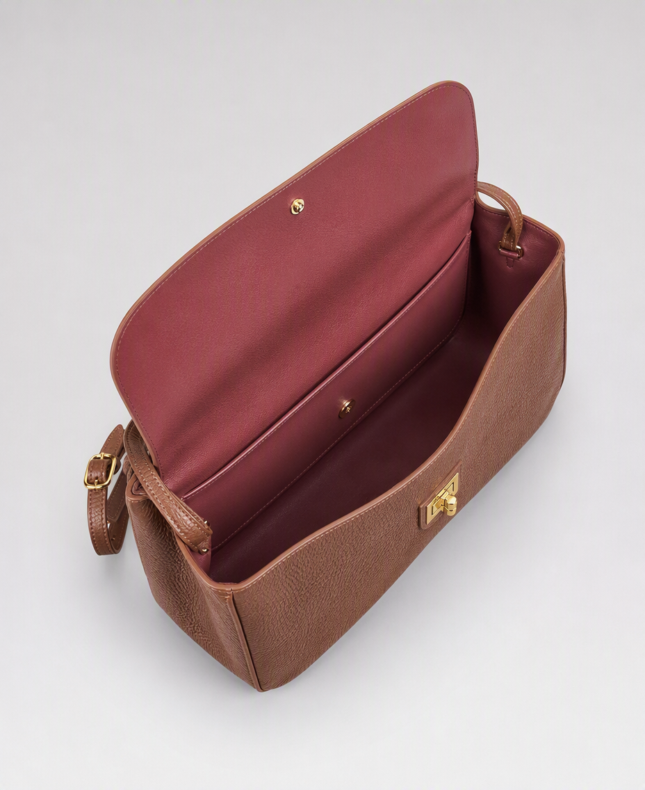 AI-generated product photograph for Hope Roza: the Trove 26 bag shown open from above, revealing a burgundy suede-look lining, an inner zip pocket and a magnetic snap under the flap